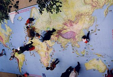 広場の床に描かれた世界地図上で遊ぶ子供達