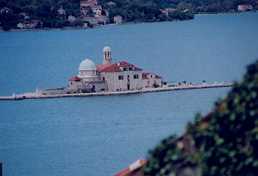 静かな港内の水辺に浮かぶ船の様な雰囲気の島と教会。